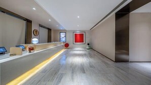 A reception area with a counter, a red accent wall, and a modern design.
