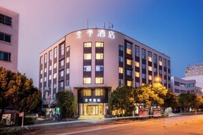 Un hotel de varios pisos con una fachada curva, numerosas ventanas y un letrero que indica que es un hotel.