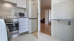 Cocina moderna con horno integrado, microondas y refrigerador.