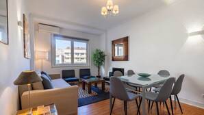 Una sala moderna con un sofá, una mesa de centro y un comedor con sillas y una mesa.