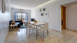 Un salon moderne comprenant un coin repas, un canapé, une table basse et un téléviseur.