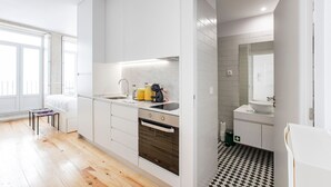 Una cocina moderna con horno empotrado, lavamanos y cafetera.