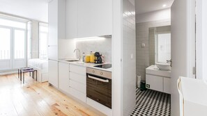A modern kitchen with a built-in oven, a sink, and a coffee machine.