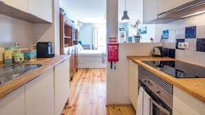 A compact kitchen with wooden cabinets, a coffee machine, and a kettle. - Lisbon Heart Apartments - Yellow, by LovelyStay (Lisboa)
