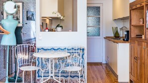 A kitchen with a round table and two chairs, a wooden cabinet, and a decorative mirror. - Lisbon Heart Apartments - Yellow, by LovelyStay (Lisboa)