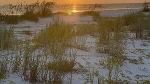 A sunset over a beach with sand and sparse vegetation. - Family Fun only steps away from Saint Joe Beach! Gulf Views!! Swim Spa 15ftx7ft! (Port St. Joe)