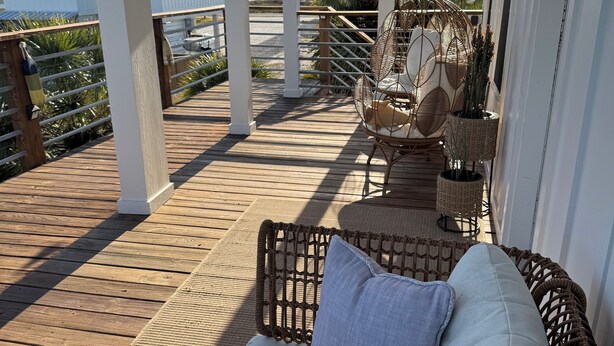 A covered outdoor seating area with wicker furniture and a ceiling fan. - Family Fun only steps away from Saint Joe Beach! Gulf Views!! Swim Spa 15ftx7ft! (Port St. Joe)