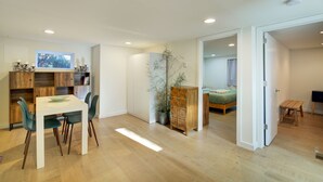 Un espace de vie moderne, à aire ouverte, comprenant un coin repas, une chambre et un petit espace bureau.