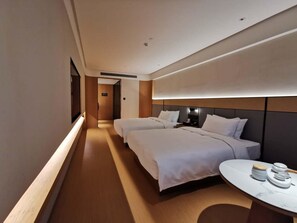 A hotel room with two beds, a bedside table with a lamp, and a view of the hallway. - Ji Hotel (Nanjing)