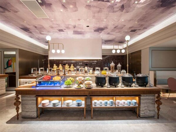 A buffet setup with various food items and serving dishes. - Ji Hotel (Nanjing)