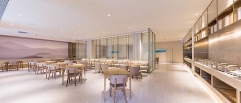 A modern dining area with a long counter, multiple seating options, and a large wall mural.