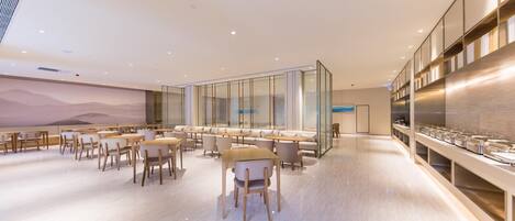 A modern dining area with a long counter, multiple seating options, and a large wall mural.