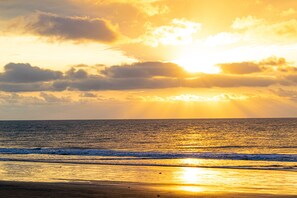 En la playa, sillas reclinables de playa, sombrillas, toallas de playa