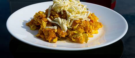 Un plato de huevos revueltos con queso sobre un plato blanco.