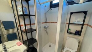A bathroom with a sink, toilet, and shower.