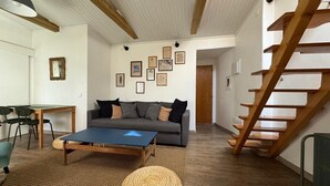 Uma sala de estar moderna com um sofá, mesa de centro e escada.