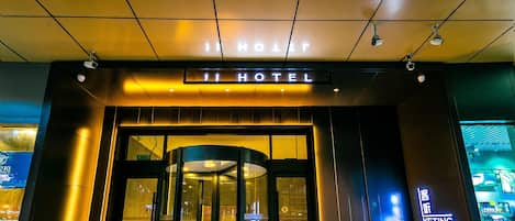 A hotel entrance with a revolving door and a sign indicating 'HOTEL'.