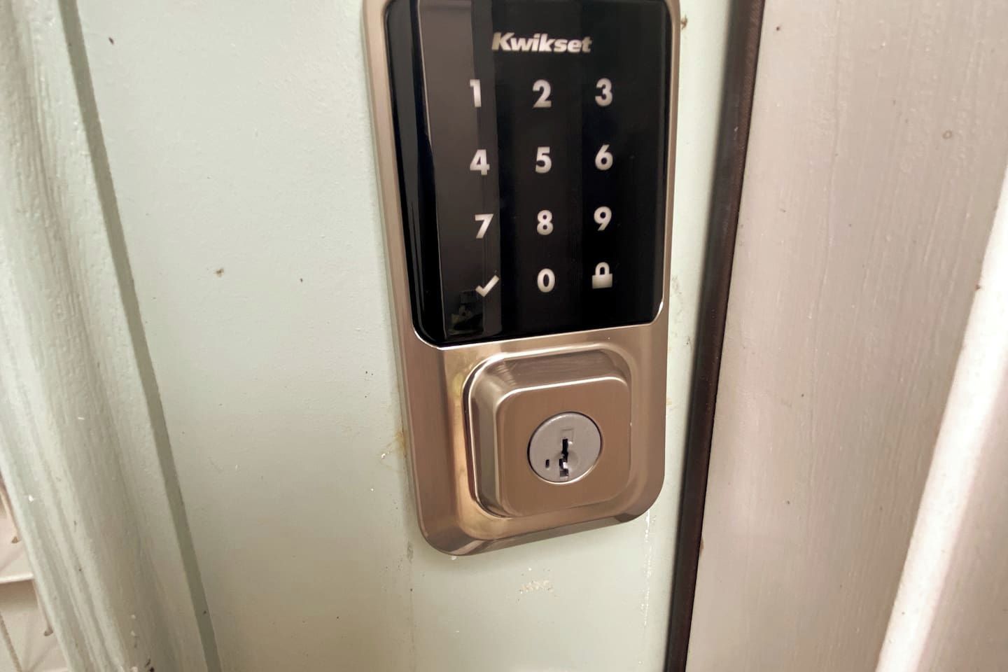 Ett Kwikset-lås med numeriskt tangentbord på en dörr.
