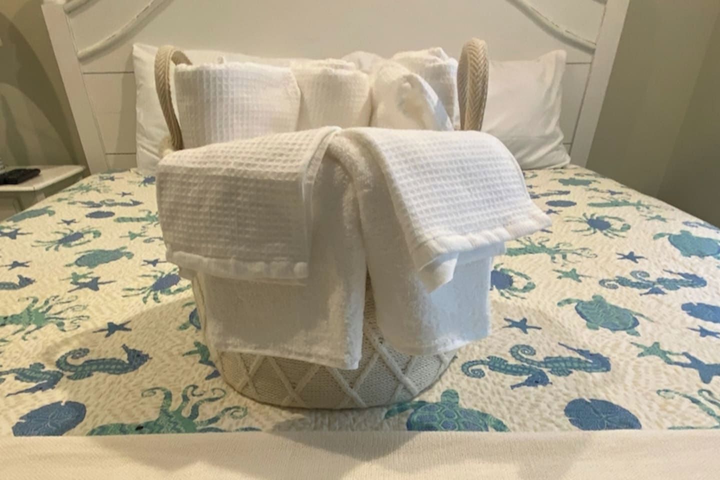 Ein Bett mit einem weißen Kopfteil und einer gesteppten Bettdecke.