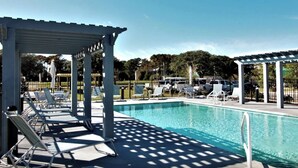 A swimming pool with lounge chairs and shaded areas. - Dog Friendly Luxury Condo, Walk to the Beach (Corolla)