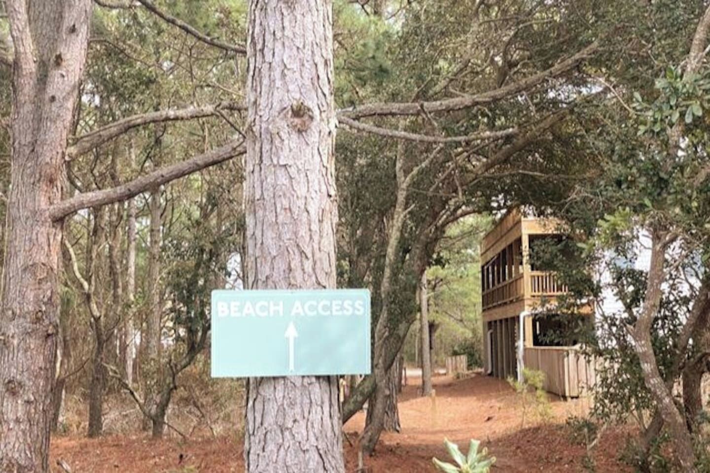A sign indicating beach access with a directional arrow.