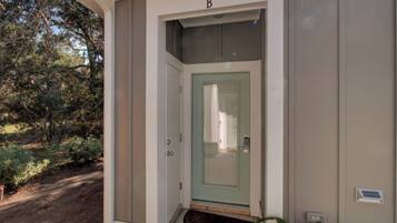 A building entrance with a green door, a mailbox, and a small porch area.