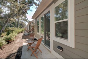 Private outdoor patio with cozy seating and a peaceful setting. - Dog Friendly Luxury Condo, Walk to the Beach (Corolla)
