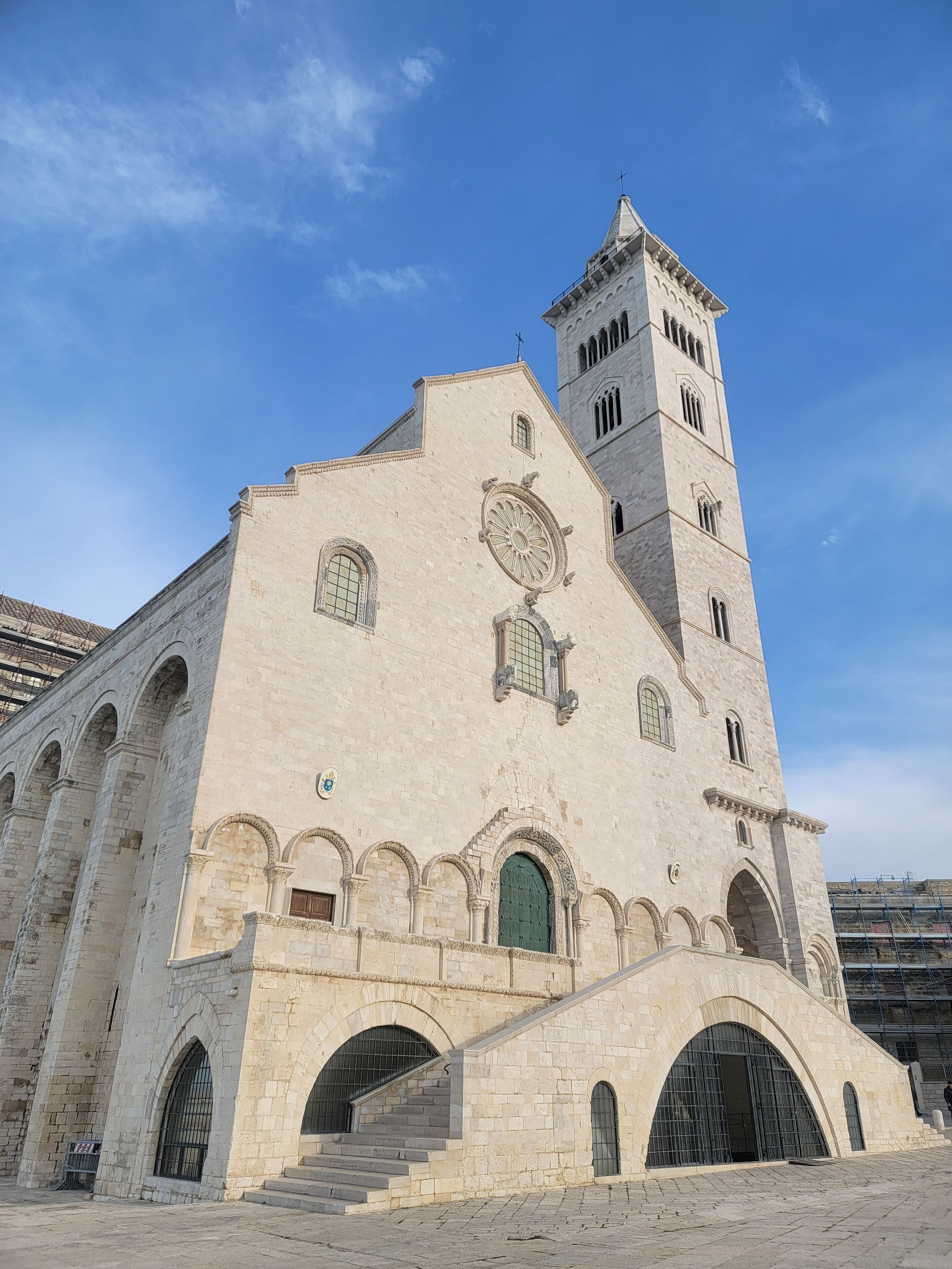 Un bâtiment historique doté d’une tour imposante, de fenêtres en arc de cercle et d’une grande porte centrale.