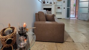 Uma sala de estar acolhedora com um sofá marrom, uma mesa de centro de vidro e uma lareira.