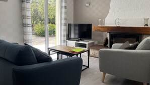 A modern living room with a sofa, a TV, and a fireplace. - Holiday home - 1-6 person(s) - quiet location - large fenced property (Méjannes-le-Clap)