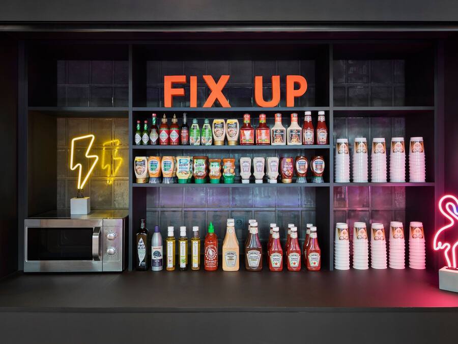Zona de bar con un letrero de neón que dice "FIX UP" y estantes llenos de botellas y copas.