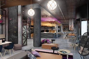 A spacious cafe with modern furniture, a large pillar, and hanging lights.
