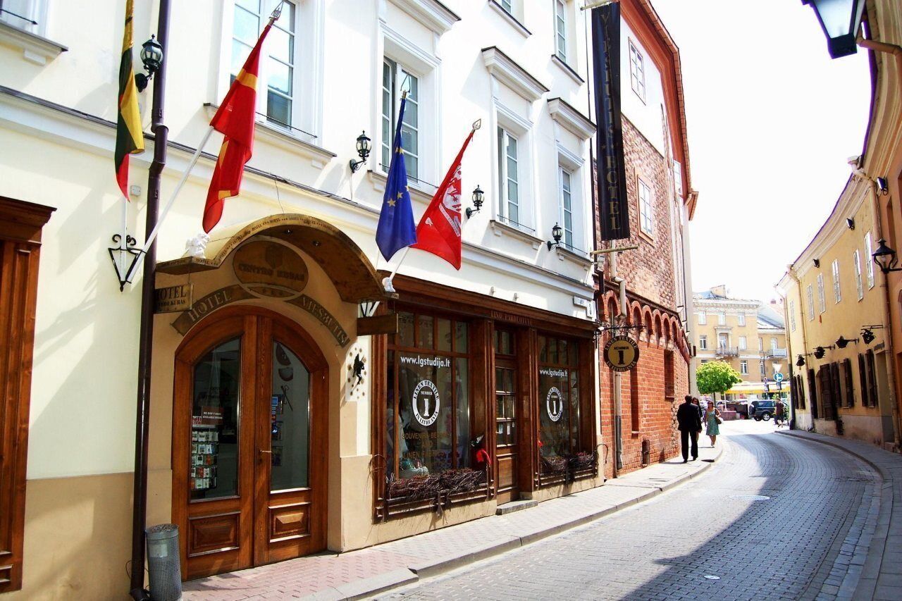 A hotel with a classic facade, large windows, and a sign indicating it is a hotel.