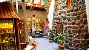 A cozy courtyard with stone walls, a wooden bench, and a vintage carriage. - Centro Kubas - Angel (Vilnius)