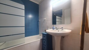 A bathroom with a white sink, blue and white tiles, a mirror, and a towel hanging on a towel rack. - Albufeira Balaia Mar e Sol (Albufeira)