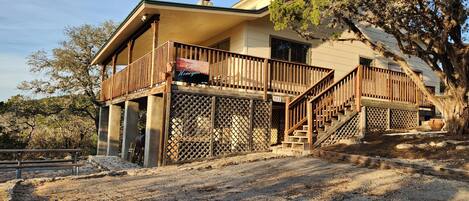 A two-story building with a balcony, a staircase, and a fenced outdoor area.
