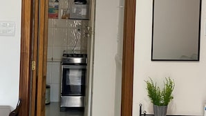 Eine Küche mit Kühlschrank, Backofen und Mikrowelle.