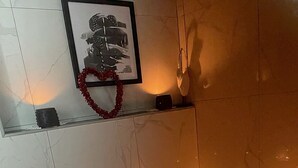 A spa bath with a mosaic floor, candles, and a framed picture above it. - SEMENI ASANTE GUESTHOUSE (Johannesburg South)
