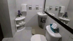 Een compacte, moderne badkamer met toilet, wastafel en spiegel.