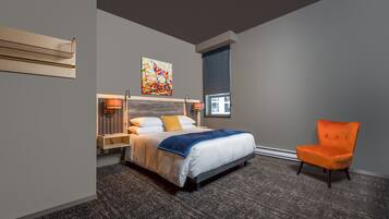 Quarto de hotel moderno com uma cama grande, uma cadeira, um quadro e uma janela.