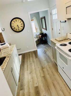 Enjoy cooking in this kitchen with a stove and sink, connected to a separate room.