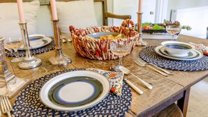 A wooden dining table set with plates, cutlery, and a basket of snacks. - 2 bedroom accommodation in Tenbury Wells (Tenbury Wells)