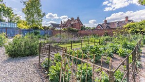 A garden with raised beds and a brick house in the background. - 2 bedroom accommodation in Tenbury Wells (Tenbury Wells)