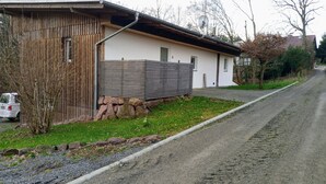 Un bâtiment d’un seul étage, doté d’un toit en pente, de fondations en pierre et d’une clôture en bois.