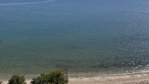 A clear view of a calm sea with a distant shoreline and a clear sky. - Sea Salt escape/ Beachfront apartment (Portmore)