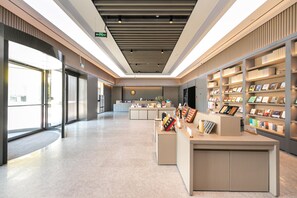 A modern interior with a reception desk, bookshelves, and a clean, well-lit space. - Ji Hotel (Hangzhou)