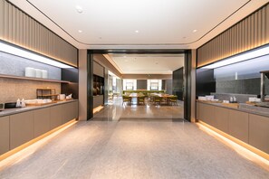 A modern hotel lobby with a central seating area, a reception desk, and a large mirror on one wall. - Ji Hotel (Hangzhou)