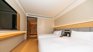 Une chambre d’hôtel avec deux lits, une télévision, une table de chevet et un téléphone.