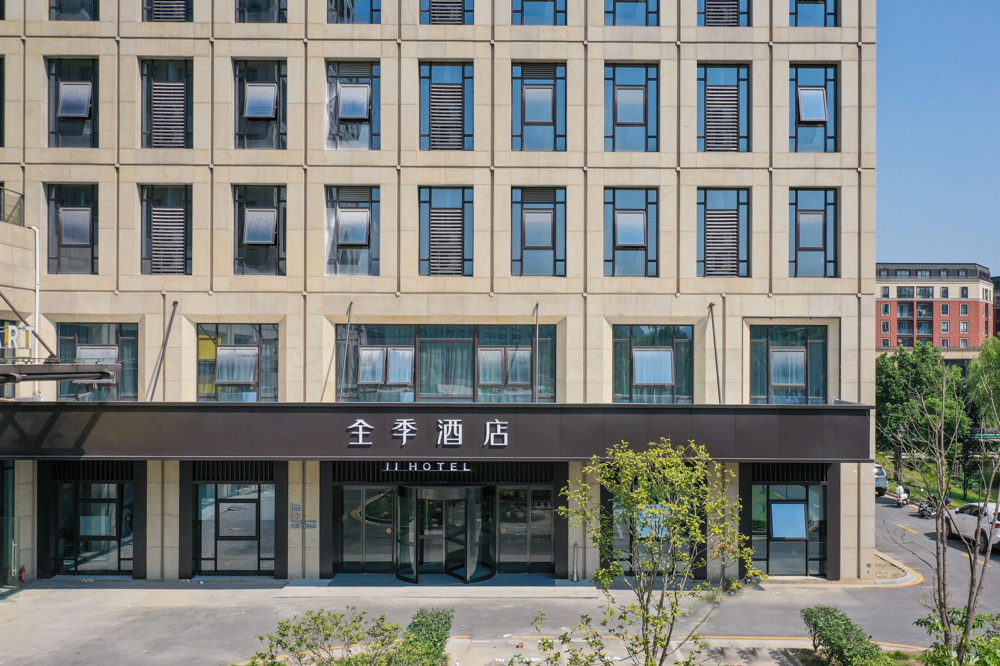 A hotel with a modern facade, multiple windows, and a sign indicating it is a hotel.