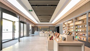 Un intérieur moderne comprenant un comptoir d’accueil, des étagères et un espace propre et bien éclairé.